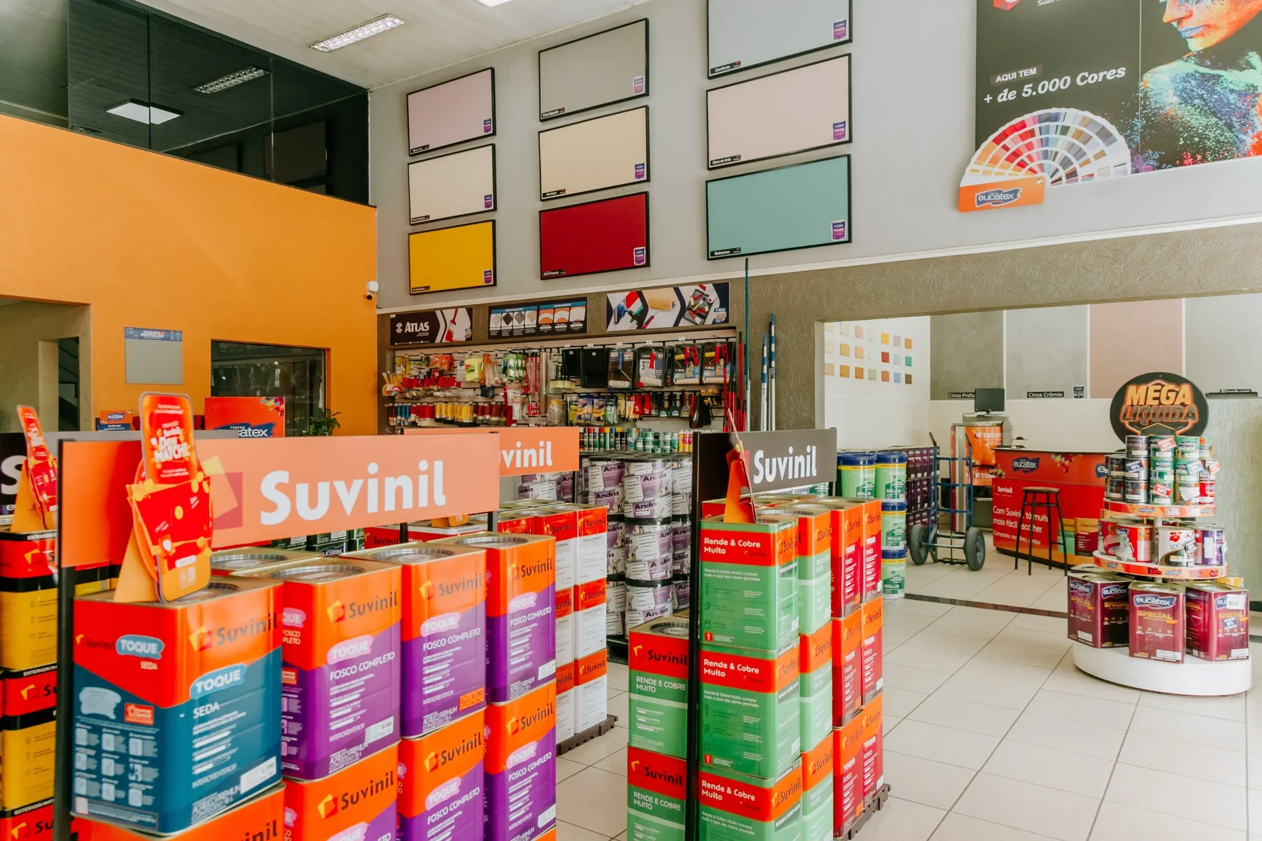 Parede com cartelas de cores Suvinil e Eucatex no salão da loja Tintas Andra